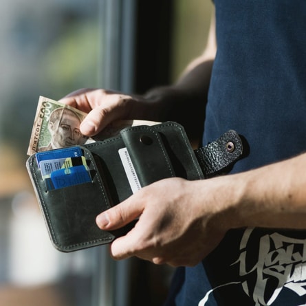 A person removing money from their wallet.